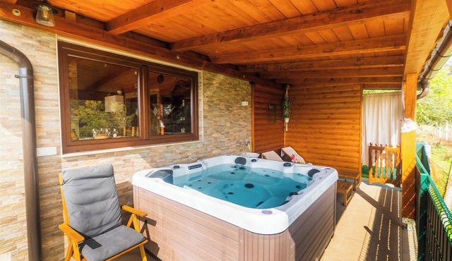 Wooden retreat with jacuzzi, sauna and nature views.